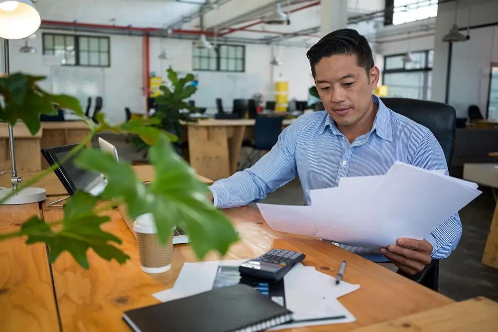 Business owner reviewing financial documents and expansion plans for future business growth and investment.