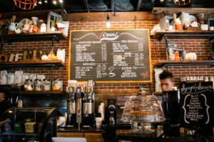 Coffee shop owner serving customers after receiving startup business loan funding.